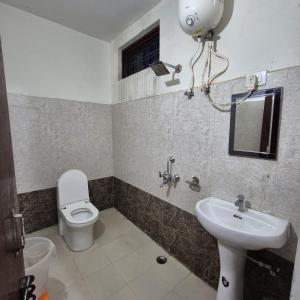 ein Badezimmer mit Toilette und Waschbecken in der Unterkunft Devadidev Retreat in Gupta Kāshi