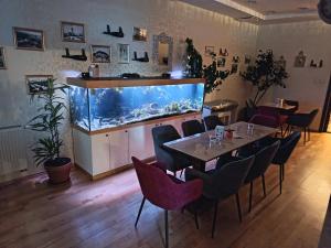 a restaurant with a fish tank and a table and chairs at Boutique Hotel Empress in Rožňava