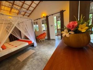 a room with two beds and a vase of flowers at La Perla Bentota in Bentota +119 photos