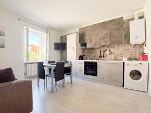 a kitchen and dining room with a table and appliances at Apartment Verdi BARDOLINO in Bardolino