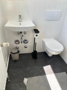 a white bathroom with a sink and a toilet at Apartment Altstadt Stralsund in Stralsund