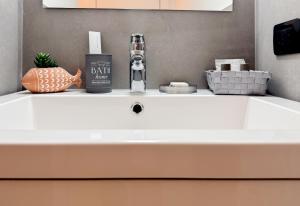 a white bathroom sink with a bottle of bath fluid at Apartment Verdi BARDOLINO in Bardolino