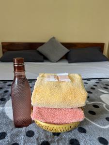 a bedroom with a bed and a table with a bottle at Geetham Homestay in Tiruchirappalli
