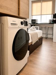 a washing machine in a room with a bed at Grand Central House - Classic Studio - GibraltarStay Apartments in Gibraltar +16 photos