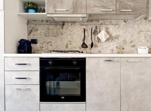 a kitchen with white cabinets and a black oven at Apartment Verdi BARDOLINO in Bardolino +4 photos