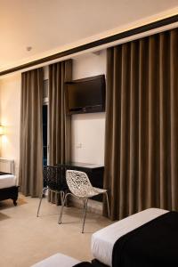 a hotel room with a bed and a chair and a television at Hôtel le calife in Tunis