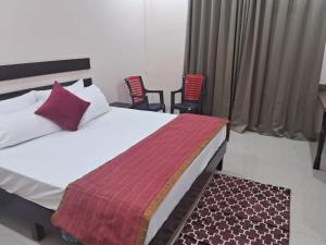 a bedroom with a bed and two chairs at Shivansh Hotel in Kānda +13 photos
