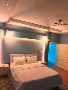 a bedroom with a large bed with a blue wall at شالية الرايس in Rayyis
