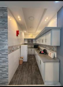 a kitchen with white cabinets and a white refrigerator at شالية الرايس in Rayyis