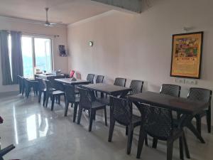 a dining room with tables and chairs and a window at Shivansh Hotel in Kānda