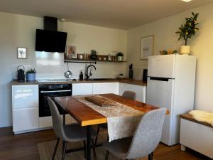 a kitchen with a table and a white refrigerator at Appartement Frieda in Seeboden