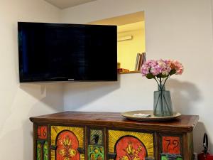 a vase of flowers on a table with a tv at Appartement Frieda in Seeboden