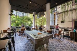 a pool table in a room with people sitting at tables at Drift Backpackers Hostel in Hanoi