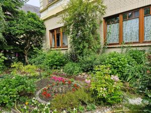 a garden in front of a house with flowers at Apartment 4 nähe Elmshorn Barmstedt in Bokholt-Hanredder