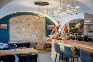 ein Restaurant mit Steinmauer, Tischen und Stühlen in der Unterkunft Hotel Korek in Frýdek-Místek