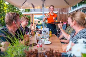 a woman standing at a table with a group of people at Vakantiepark Witterzomer Assen in Assen
