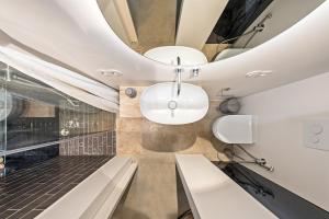 a room with a bench and two lights on the ceiling at Raw Luxury Loft in Vilnius in Vilnius +33 photos