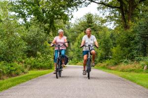 two older people riding bikes down a road at Vakantiepark Witterzomer Assen in Assen