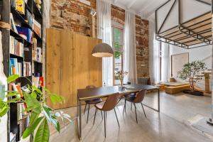 a dining room with a table and chairs and a brick wall at Raw Luxury Loft in Vilnius in Vilnius