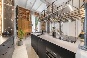 an industrial kitchen with a large white counter top at Raw Luxury Loft in Vilnius in Vilnius