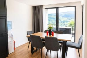 a dining room with a table and chairs and a window at CBN Cabana in Muntele Cacovei