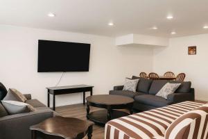 a living room with a couch and a flat screen tv at Mountain Views - Peaceful Retreat - 1BR suite in Sooke