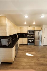 a kitchen with wooden cabinets and stainless steel appliances at Mountain Views - Peaceful Retreat - 1BR suite in Sooke +12 photos