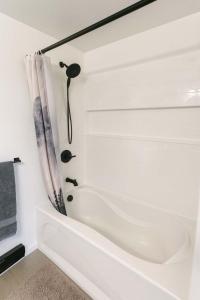 a white bath tub in a bathroom with a shower curtain at Mountain Views - Peaceful Retreat - 1BR suite in Sooke