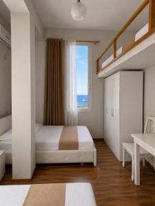 a bedroom with a bed and a large window at British Hotel in Himare