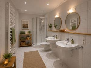 a bathroom with two sinks and a shower and a toilet at Heidhof in Bispingen +63 photos