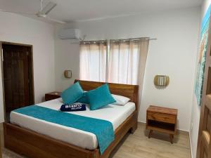 a bedroom with a bed with blue pillows at Blissful hill top Apartment in Praslin