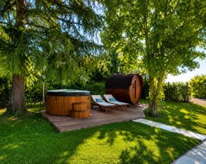 a backyard with a barrel and two chairs and a table at VM Boutique in Castiglione di Ravenna