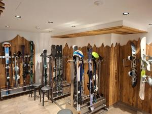 a room with a bunch of skis on the wall at Hotel Garni Bel-Ami in Galtür +39 photos