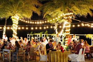 a group of people sitting at tables in a restaurant with lights at Fair House Villas & Spa, Koh Samui in Mae Nam +118 photos