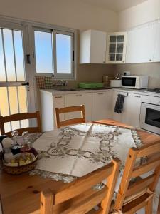 a kitchen with a wooden table with chairs and a table sidx sidx sidx at Indie little house in Limassol