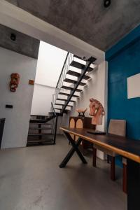 a dining room with a wooden table and stairs at The Embrace Luxury Villa - Hiriketiya in Dickwella