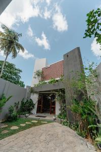 an exterior view of a house with a palm tree at The Embrace Luxury Villa - Hiriketiya in Dickwella
