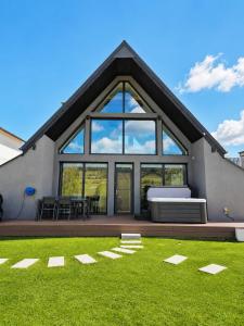 a house with a large window and green grass at CBN Cabana in Muntele Cacovei