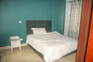 a bedroom with a bed and a blue wall at Hidden Gems Homes Modern 2BR Near JKIA, Athi River in Athi River