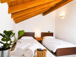 two beds in a room with white walls at Residenza La Torre Pizzighettone in Pizzighettone