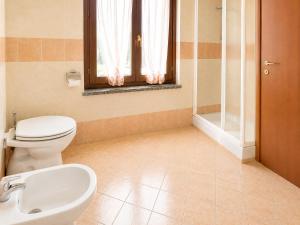 a bathroom with a toilet and a sink and a window at Residenza La Torre Pizzighettone in Pizzighettone