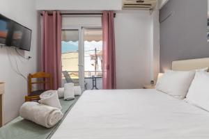 a bedroom with a large white bed and a window at ΤΗΕRAMVOS in Pefkochori
