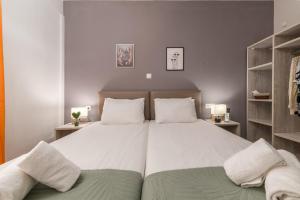 a bedroom with a large white bed with two pillows at ΤΗΕRAMVOS in Pefkochori