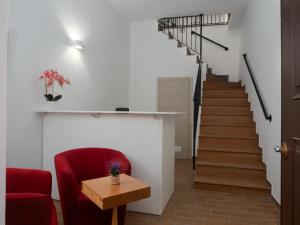 a living room with a red chair and stairs at B&B La Via dei Mulini in Corigliano Calabro