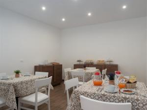 a dining room with two tables and white chairs at B&B La Via dei Mulini in Corigliano Calabro