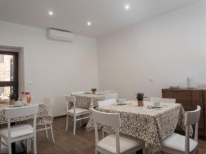 a dining room with two tables and white chairs at B&B La Via dei Mulini in Corigliano Calabro +30 photos