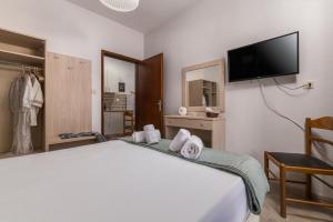 a hotel room with a bed and a flat screen tv at ΤΗΕRAMVOS in Pefkochori