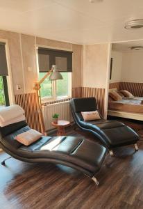 a room with two chairs and a bed in it at Bos & Bubbels Chalet in Epe