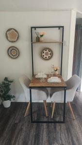 a dining room table with two chairs and a table with wine glasses at Bos & Bubbels Chalet in Epe +19 photos