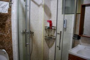 a shower in a bathroom with a glass shower stall at Hidden Gems Homes Modern 2BR Near JKIA, Athi River in Athi River +7 photos